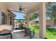 Covered back patio with ceiling fan, seating, and grill, with views of artificial grass at 5024 S Citrus Ct, Gilbert, AZ 85298