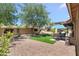 Artificial grass backyard area with covered patio, rock landscaping, and block wall at 5024 S Citrus Ct, Gilbert, AZ 85298