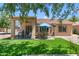 Landscaped backyard featuring a covered patio, artificial grass, and desert foliage at 5024 S Citrus Ct, Gilbert, AZ 85298