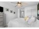Bright bedroom features a ceiling fan, soft white bedding, and curated wall art at 5024 S Citrus Ct, Gilbert, AZ 85298