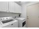 Well-lit laundry room with a side-by-side washer and dryer and ample cabinet space at 5024 S Citrus Ct, Gilbert, AZ 85298
