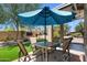 Inviting patio with ample seating, an umbrella for shade, and a well-maintained artificial grass lawn at 5024 S Citrus Ct, Gilbert, AZ 85298