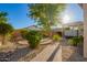 Paver pathway and desert landscaping in backyard with mature tree and hot tub at 5607 W Alyssa Ln, Phoenix, AZ 85083