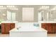 Bright bathroom with dual sink vanity, soaking tub, and wood cabinets at 5607 W Alyssa Ln, Phoenix, AZ 85083