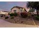 Landscaped yard with decorative rock and blooming bushes surrounding the home at 5607 W Alyssa Ln, Phoenix, AZ 85083