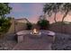 An outdoor fire pit surrounded by a semi-circular seating area sits on a brick patio with desert landscaping at 5607 W Alyssa Ln, Phoenix, AZ 85083