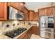Gourmet kitchen featuring gas cooktop, stainless steel appliances, and stylish backsplash at 5607 W Alyssa Ln, Phoenix, AZ 85083