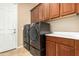 Functional laundry room with front loading washer and dryer and upper cabinets at 5607 W Alyssa Ln, Phoenix, AZ 85083