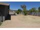 Backyard with covered patio, mostly sparse ground cover, trees, and block fence at 5634 W Puget Ave, Glendale, AZ 85302