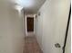 Hallway with tile flooring and two white doors leading to rooms and a visible door at the end at 5634 W Puget Ave, Glendale, AZ 85302