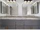 Bathroom featuring a granite double vanity with gold fixtures and framed mirrors at 6014 W Oberlin Way, Phoenix, AZ 85083