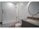 Modern bathroom features white tile, granite countertop, updated fixtures, and bathtub with shower at 6014 W Oberlin Way, Phoenix, AZ 85083