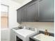 Well-equipped laundry room with washer, dryer, sink, and overhead cabinetry at 6014 W Oberlin Way, Phoenix, AZ 85083