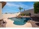 Sparkling blue pool with rock waterfall feature, surrounded by desert landscaping and privacy wall at 6014 W Oberlin Way, Phoenix, AZ 85083