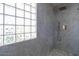 Detail of shower with stone floor, glass block window and rainfall shower head at 6014 W Oberlin Way, Phoenix, AZ 85083