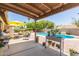 View of the covered back patio with seating area and pool in landscaped yard at 6017 E Kathleen Rd, Scottsdale, AZ 85254