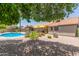 View of the backyard pool and landscaping from beneath a tree at 6017 E Kathleen Rd, Scottsdale, AZ 85254