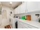 Laundry room with storage cabinets, washer, dryer and ironing board at 6017 E Kathleen Rd, Scottsdale, AZ 85254