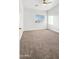 Empty carpeted bedroom featuring a ceiling fan and natural light at 6537 W Pioneer St, Phoenix, AZ 85043