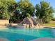 Luxury backyard with a sparkling pool, rock slide, and lush landscaping for a relaxing retreat at 661 W Via De Palmas --, San Tan Valley, AZ 85140