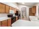 Traditional-style kitchen featuring wood cabinets, white countertops, and black appliances at 7621 S Bonarden Ln, Tempe, AZ 85284