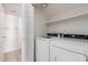 Bright laundry room with washer, dryer, and shelving unit at 7621 S Bonarden Ln, Tempe, AZ 85284