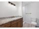 Bright bathroom featuring modern lighting, granite countertop, and tile shower with glass door at 811 E Brown St, Phoenix, AZ 85020