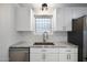 Close-up of kitchen sink area featuring white cabinetry, granite countertops, and modern fixtures at 811 E Brown St, Phoenix, AZ 85020