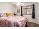 Cozy bedroom featuring a ceiling fan, window with blinds, and comfortable bed at 8609 W Eva St, Peoria, AZ 85345