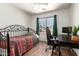 Comfortable bedroom with hardwood floors, a large window with curtains, and a desk with a gaming chair at 8609 W Eva St, Peoria, AZ 85345