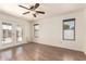 Well-lit empty room with laminate flooring, windows, and access to backyard at 8609 W Eva St, Peoria, AZ 85345