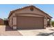 A two-car garage with a concrete driveway and low-maintenance desert landscaping at 8609 W Eva St, Peoria, AZ 85345