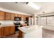 Spacious kitchen with wood cabinets, stainless steel fridge, and a central island with a farmhouse style sink at 8609 W Eva St, Peoria, AZ 85345