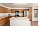 Well-lit kitchen featuring wood cabinets, stainless steel appliances, and an island with a white countertop at 8609 W Eva St, Peoria, AZ 85345