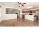 Open-concept living room showcasing hardwood floors, a ceiling fan, and seamless flow into the kitchen area at 8609 W Eva St, Peoria, AZ 85345