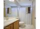 This bathroom features a single sink vanity, white toilet, shower-tub combination with a curtain and neutral color scheme at 8769 W Washington St, Tolleson, AZ 85353