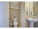 This bathroom features a pedestal sink, white toilet, and light walls at 8769 W Washington St, Tolleson, AZ 85353
