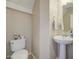 This bathroom features a pedestal sink, white toilet, and light walls at 8769 W Washington St, Tolleson, AZ 85353