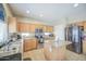 Spacious kitchen with wood cabinets, an island, stainless appliances, and a unique arched window above the sink at 8769 W Washington St, Tolleson, AZ 85353