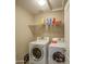 Bright laundry room with white washer and dryer, and shelving at 8769 W Washington St, Tolleson, AZ 85353