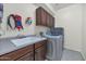 Functional laundry room includes a sink, cabinets, and modern washer and dryer at 9582 W Albert Ln, Peoria, AZ 85382