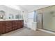 Well-lit main bathroom featuring dark wood cabinets, a soaking tub, and separate shower at 9582 W Albert Ln, Peoria, AZ 85382