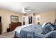 Carpeted bedroom with a ceiling fan, dresser, and a view of an open closet and bathroom at 10062 E Isleta Ave, Mesa, AZ 85209