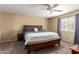 Bedroom features a large bed, ceiling fan, and a window with blinds and gray curtains at 10062 E Isleta Ave, Mesa, AZ 85209