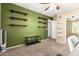 Bedroom with olive green accent wall, floating shelves, and adjacent room featuring white shelving at 10062 E Isleta Ave, Mesa, AZ 85209