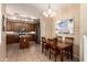 Dining area next to a spacious kitchen, featuring a wooden table set for four, with stylish lighting at 10062 E Isleta Ave, Mesa, AZ 85209