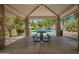 Poolside gazebo featuring stone pillars, picnic table, and lush landscaping at 10062 E Isleta Ave, Mesa, AZ 85209