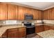 Close-up of kitchen with wood cabinets, granite countertops, mosaic backsplash, and modern stainless steel appliances at 10062 E Isleta Ave, Mesa, AZ 85209