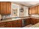 Bright kitchen featuring wood cabinets, granite countertops, stainless steel appliances, and a window over the sink at 10062 E Isleta Ave, Mesa, AZ 85209