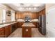 Well-equipped kitchen featuring wood cabinets, granite countertops, an island, and stainless steel appliances at 10062 E Isleta Ave, Mesa, AZ 85209